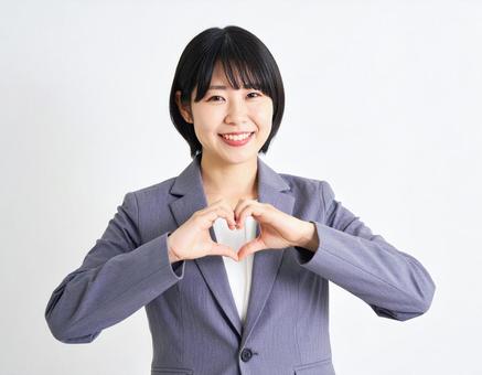 ハートマークを作るビジネスウーマンの写真
