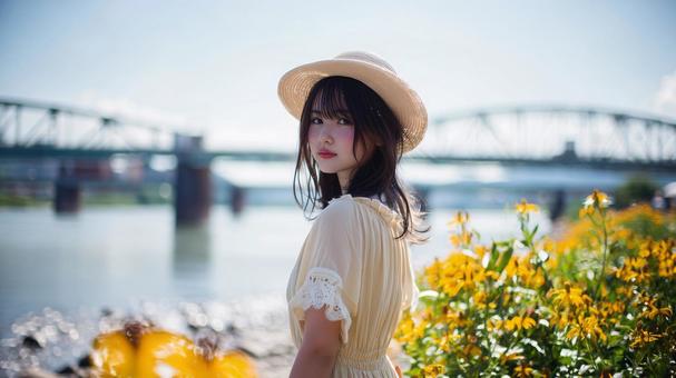河原でストローハットとワンピースの女性 河原でストローハットとワンピースの女性の写真