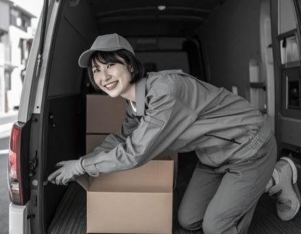トラックから荷物を出す宅配女性ドライバー トラックから荷物を出す宅配女性ドライバーの写真