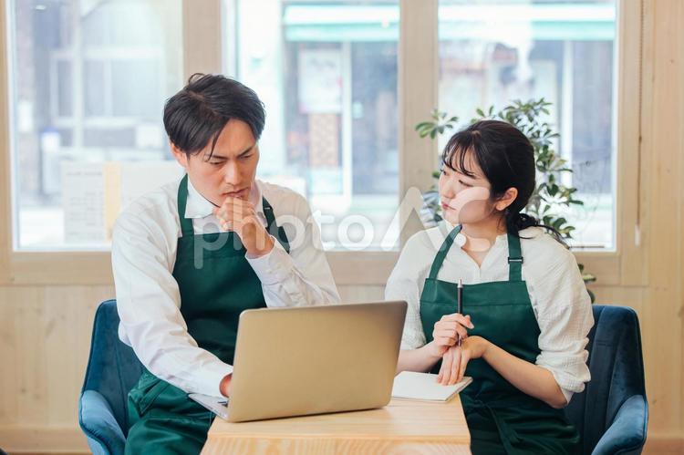 レストラン・カフェ・飲食店を経営する男女 ネットショップ,オンラインショップ,パソコンの写真素材