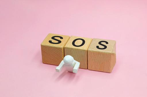 SOSと書かれたブロックに潰されている人 sos,悩み,問題解決の写真素材