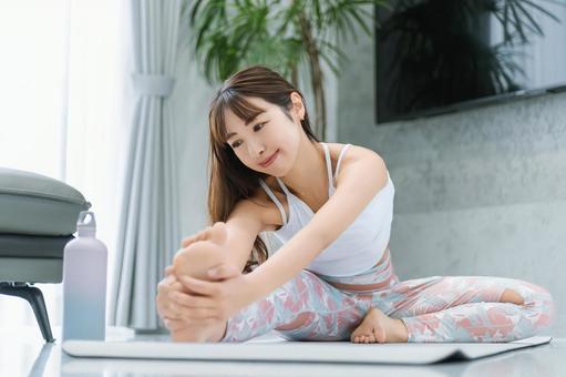 自宅のリビングでストレッチをする女性 自宅のリビングでストレッチをする女性 女性,ストレッチ,柔軟の写真素材