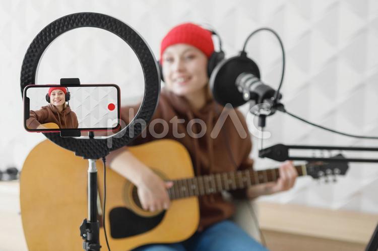 スマートフォンに映るギターの女性 スマートフォン,画面,録画の写真素材