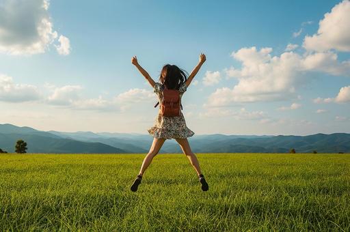 草原でジャンプするワンピースの少女の写真