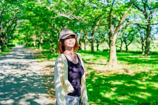 公園で散歩中に日光浴を楽しむ女性 公園で散歩中に日光浴を楽しむ女性 散歩,歩く,笑顔の写真素材