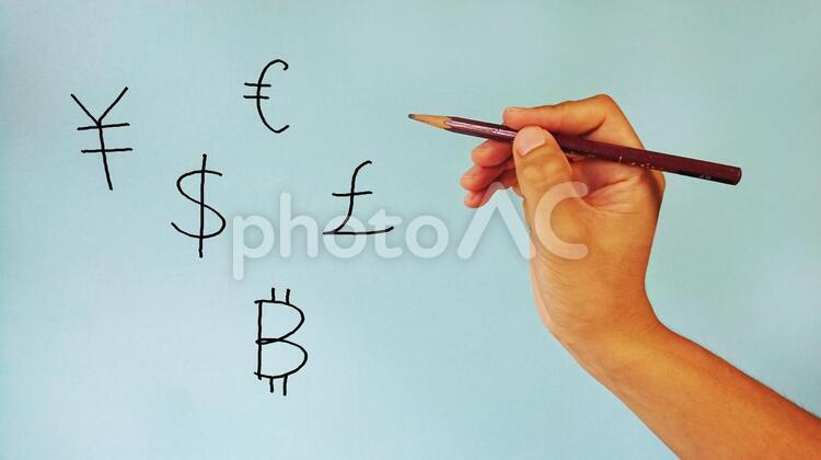 各国の通貨マークと鉛筆を持つ手 円,ドル,世界の写真素材