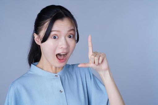 青い服の女性が指をさして強調するの写真