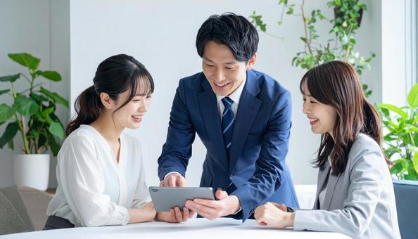 タブレットを使って説明する男性営業マン タブレットを使って説明する男性営業マンの写真