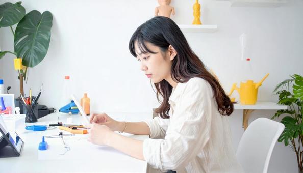 プラモデル作りに集中する女性 プラモデル作りに集中する女性の写真