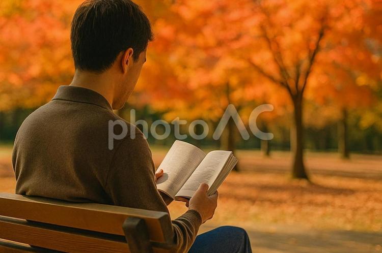 秋の公園で読書を楽しむ男性・紅葉・落ち葉 秋の公園,読書,男性の写真素材