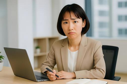 困惑するオフィス女性 困惑するオフィス女性の写真