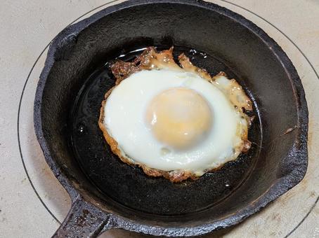 IHコンロ上の小型スキレットの玉子焼き たまご焼き,フライドエッグ,鋳鉄製フライパンの写真素材