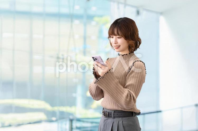 スマホを使う笑顔の女性・ビジネスウーマン 女性,スマホ,笑顔の写真素材