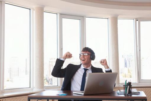 外を見てガッツポーズで喜ぶ男性 男性,外国人,ガッツポーズの写真素材