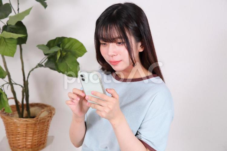 部屋着でスマートフォンを操作する女性 女性,若い,20代の写真素材