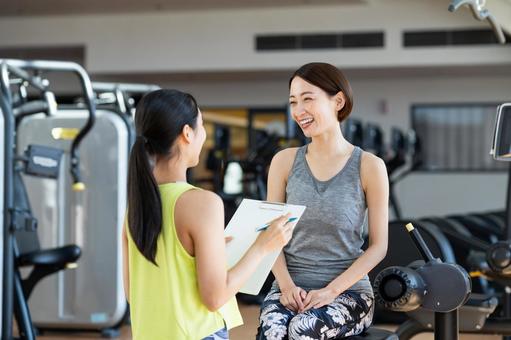 ジムでカウンセリングを受けるミドルの女性 ジム,フィットネス,カウンセリングの写真素材