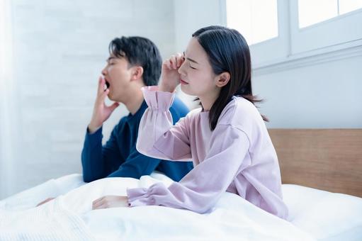 ベッドで体調不良の二人 女性,男性,目覚めの写真素材