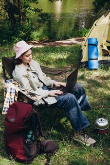 椅子でPCを操作する人物 女性,外国人,キャンプの写真素材