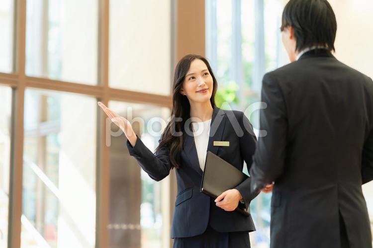 お客を案内するホテルマンの女性 フロント,ホテルマン,コンシェルジュの写真素材