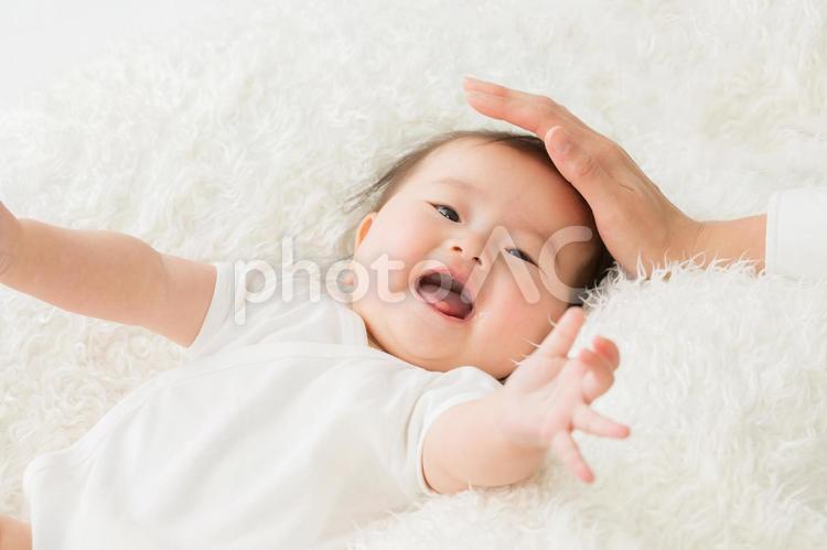 女性に撫でられる赤ちゃん（笑顔） 赤ちゃん,なでる,母親の写真素材