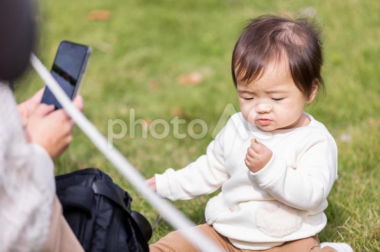 公園で遊ぶ赤ちゃんを撮影するママ（無関心） 赤ちゃん,撮影,写真の写真素材