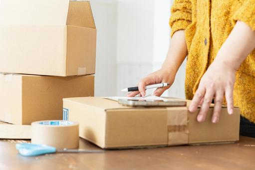 荷造りする女性の手元 荷造りする女性の手元 段ボール,荷造り,ガムテープの写真素材