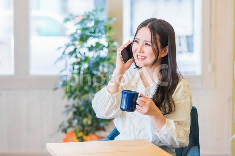 コーヒーを飲みながらスマホで会話する女性 スマホ,電話,スマートフォンの写真素材