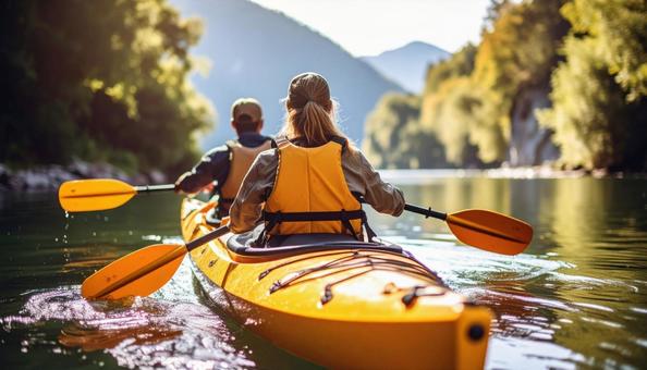 カヤックに乗ってオールをこぐカップル カヤックに乗ってオールをこぐカップルの写真