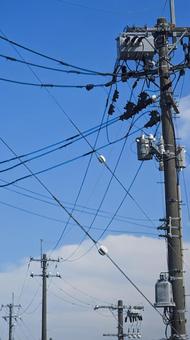青い空を横切る複雑に絡み合う電線と電柱 青い空を横切る複雑に絡み合う電線と電柱 電線,電柱,青空の写真素材