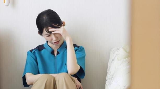 介護の仕事で疲れるアジア人介護士 介護の仕事で疲れるアジア人介護士 介護士,介護福祉士,女性の写真素材