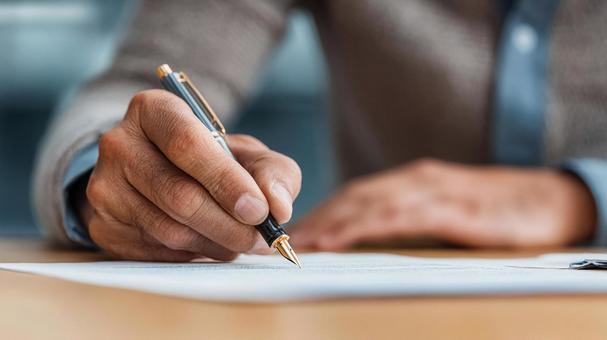 ペンで紙に書く手のクローズアップ ペンで紙に書く手のクローズアップの写真