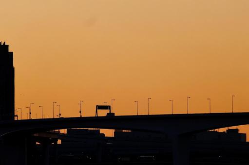 夕焼けの高速道路シルエット 夕焼けの高速道路シルエットの写真
