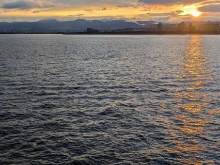 鹿児島市街地に沈む夕日、茜色の空と海 鹿児島市街地に沈む夕日、茜色の空と海の写真