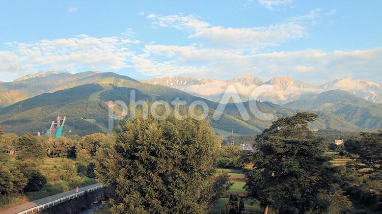 朝日を浴びる白馬の山々とジャンプ競技場 白馬連峰,朝日,夏の写真素材