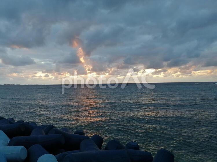 雲の間から夕陽が差し込み海に映える 海,日の光,夕日の写真素材