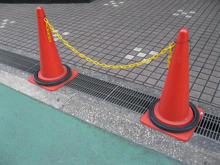 黄色チェーンでつながれた三角コーン 三角コーン,赤,カラーコーンの写真素材