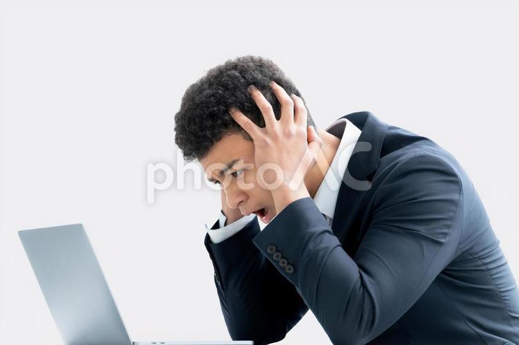 頭を抱えて困る若い外国人ビジネスマン 男性,ビジネスマン,ビジネスの写真素材