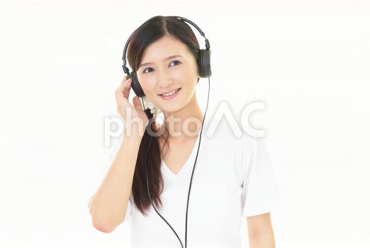 音楽を聴く笑顔の女性 女性,ヘッドフォン,女の写真素材