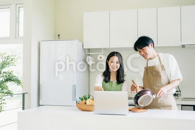 家事を手伝う男性と女性（パソコン） キッチン,夫婦,パソコンの写真素材