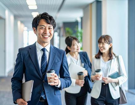 オフィスの廊下で談笑するビジネスパーソンの写真