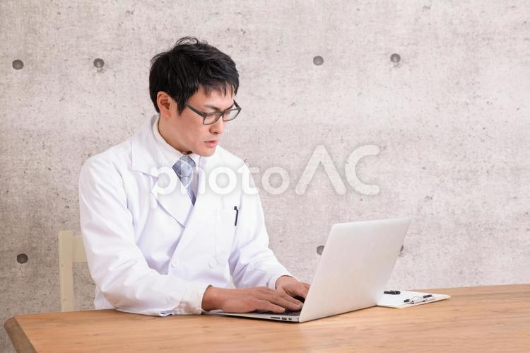 白衣を着た男性 オンライン診療,医者,悩むの写真素材