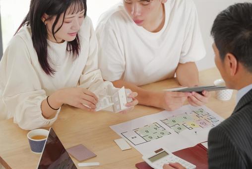 営業マンと家づくりの相談をする若い夫婦 営業マンと家づくりの相談をする若い夫婦 住宅,家,新築の写真素材