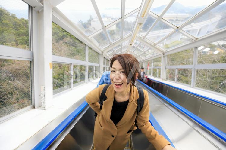 エスカレーターに乗る女性 女性,人物,日本人の写真素材
