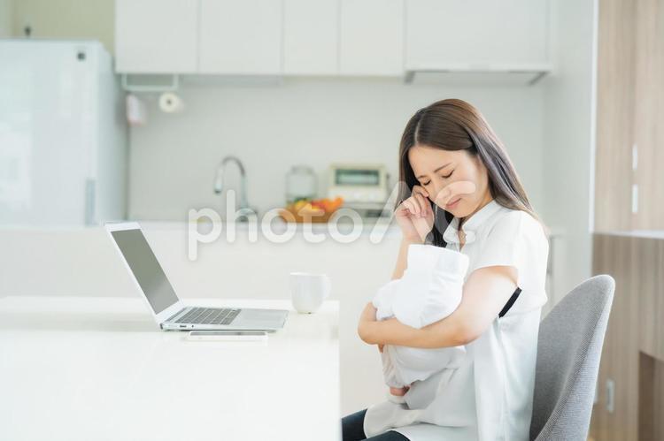 赤ちゃんと仕事で悩む女性 育児ノイローゼ,赤ちゃん,テレワークの写真素材