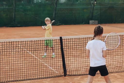 子供たちのテニス対決の写真
