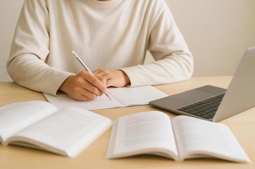 ノートとパソコンで勉強する学生の写真
