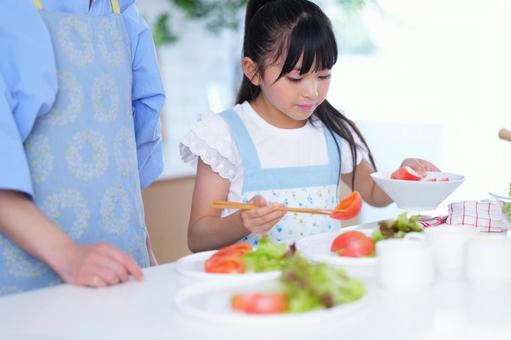 料理を仕上げる子どもの丁寧な手元 女の子,トマト,野菜の写真素材