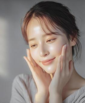 スキンケア後の肌の潤いを感じる若い女性 スキンケア後の肌の潤いを感じる若い女性の写真