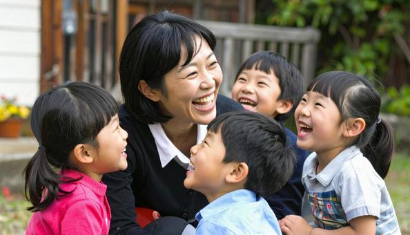 園児たちに囲まれる笑顔の日本人女性　の写真