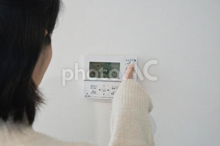 給湯機を操作してお風呂にお湯をはる女性 女性,顔なし,給湯機の写真素材